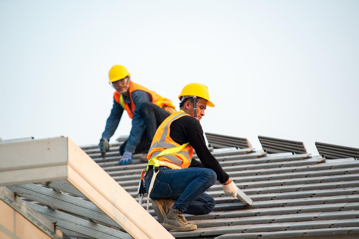 Expert workers installing an asphalt roof in London, UK